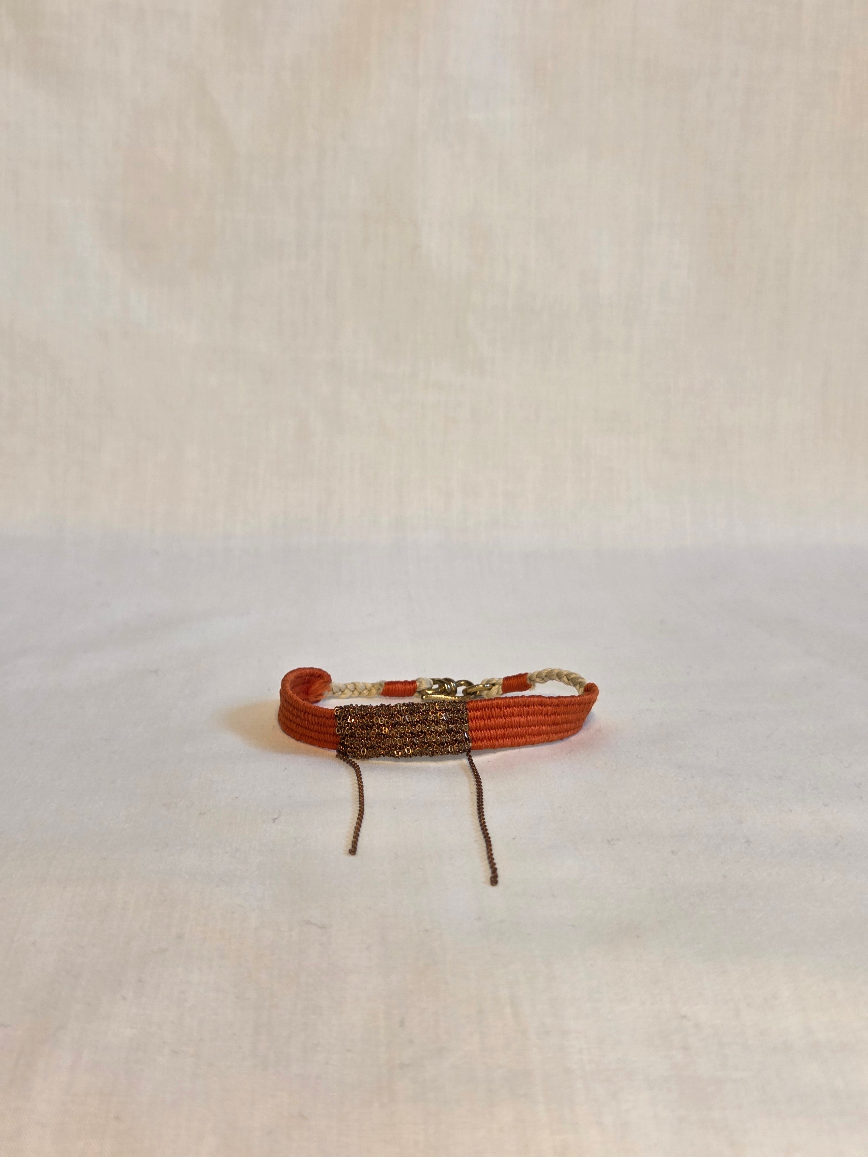 Small red and brown bracelet on a light beige background